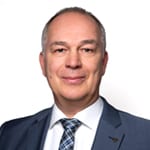 Headshot of Jan Hoelscher wearing a black suit with a white shirt