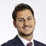 Headshot of Nick Konczol smiling, wearing a suit