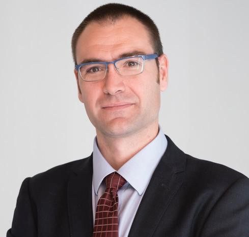 Headshot of Sergio, wearing a black suit.