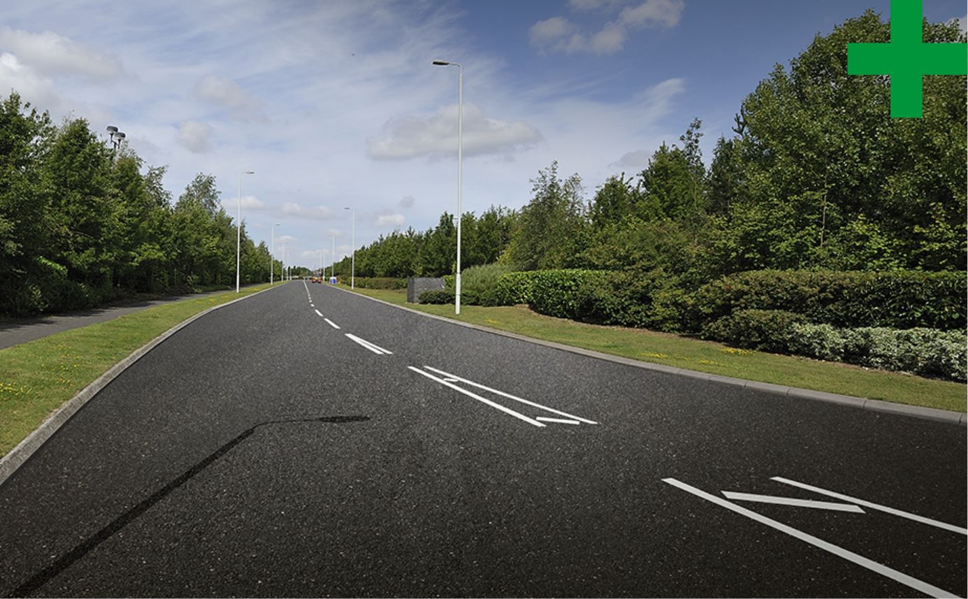 Road with trees either side, with a green cross in top right hand corner.