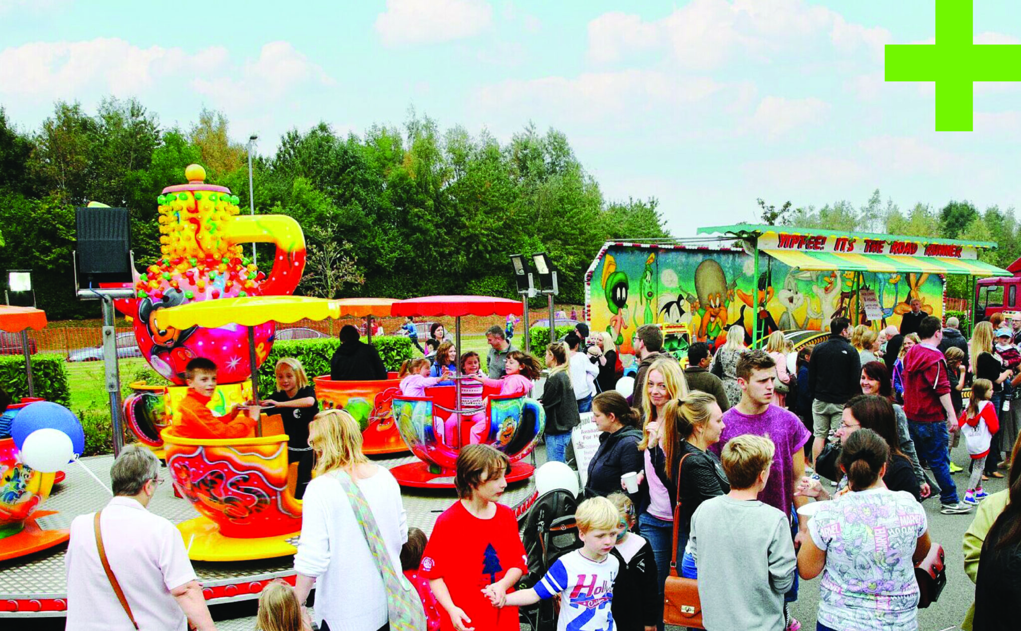 Community event at GLP with carnival rides and a large crowd of children and adults.
