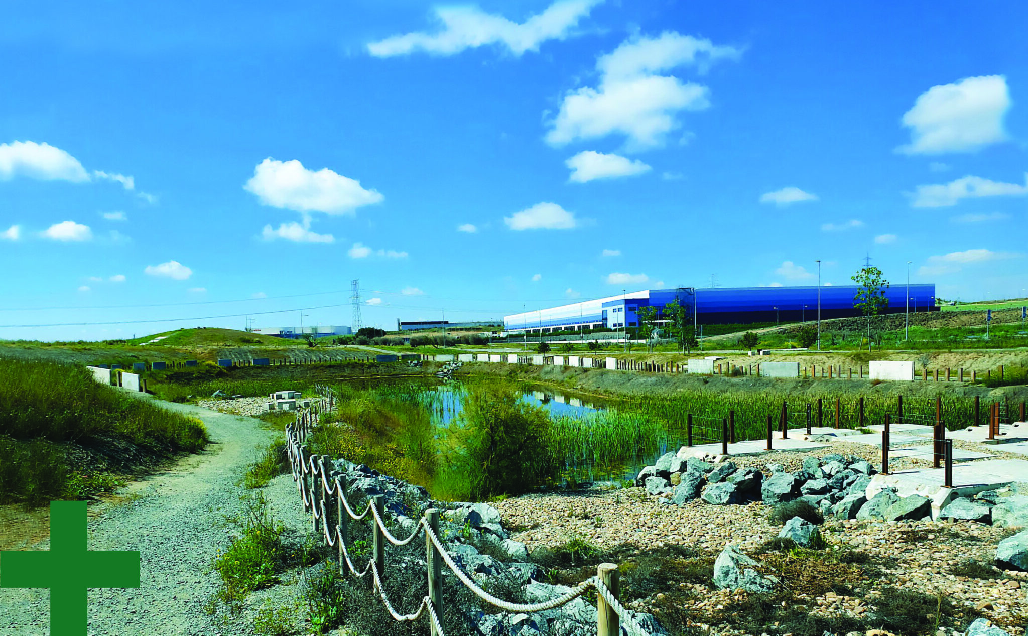 Nature surrounding a warehouse, including greenery and a lake.